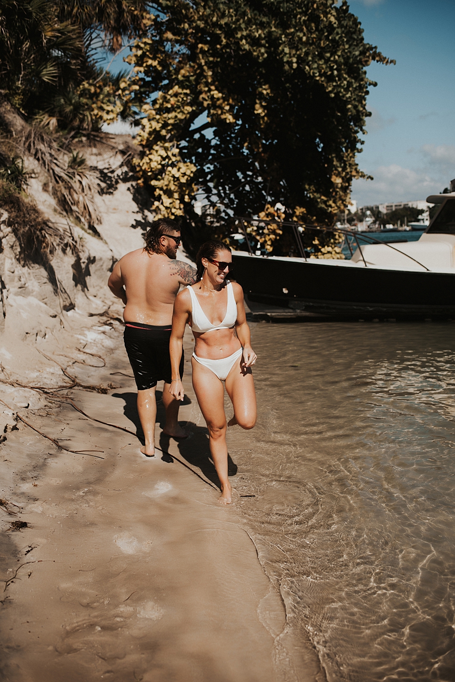Bride and groom in bathing suits on beach