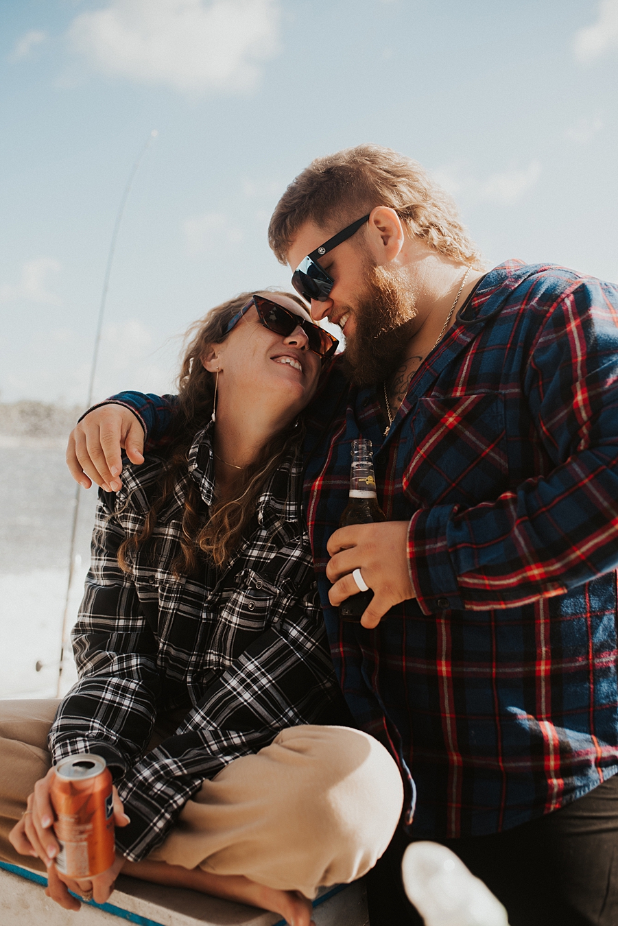 Bride and groom in flannel cuddling on boat