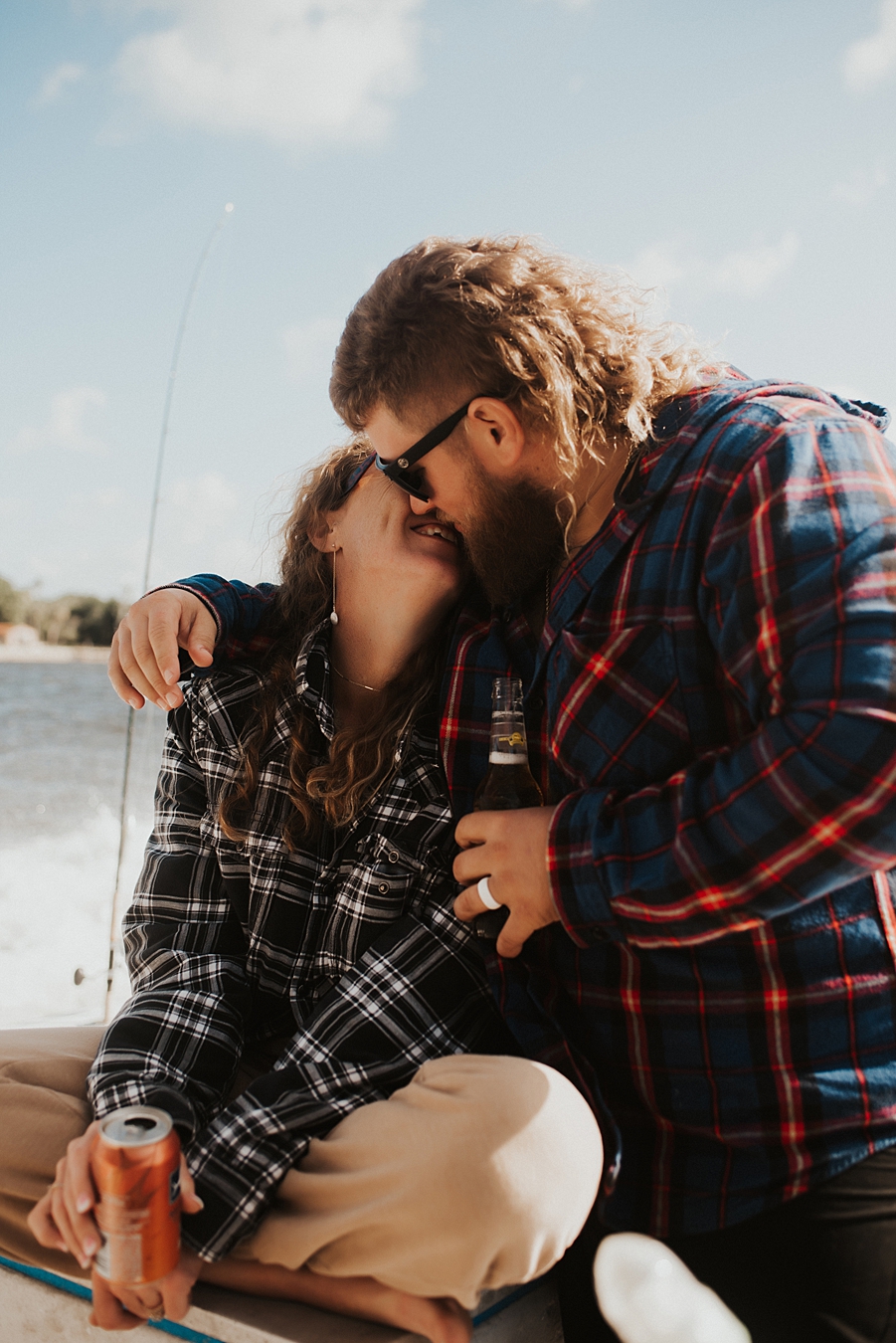 Bride and groom in flannel cuddling on boat