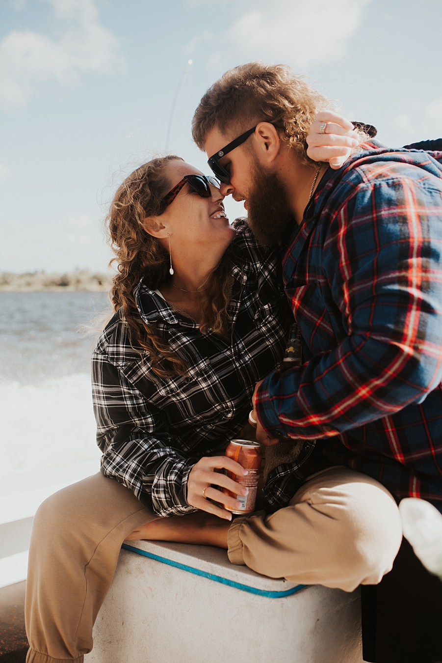 Bride and groom in flannel cuddling on boat
