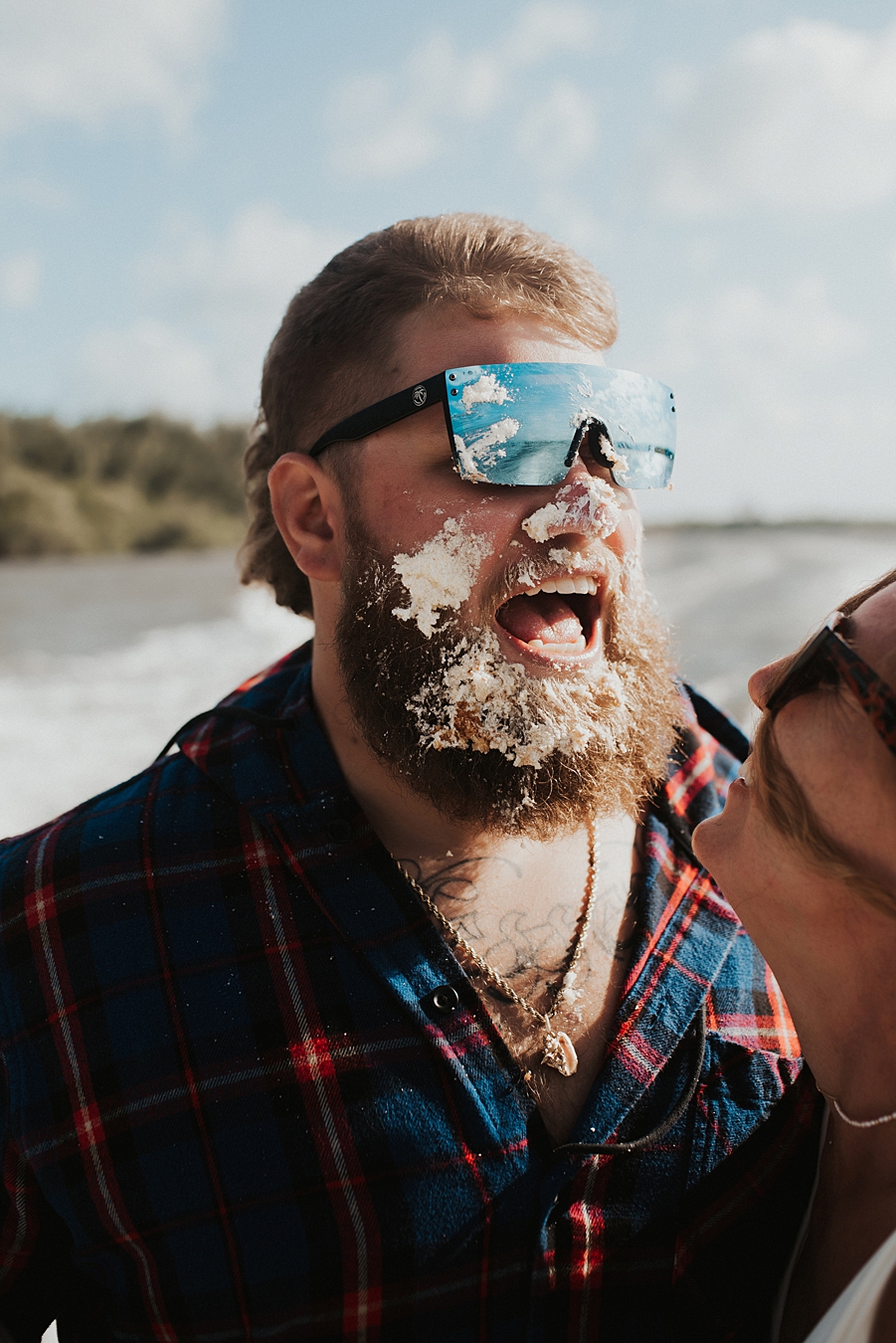 Bride in bikini smashing cake into grooms face on boat