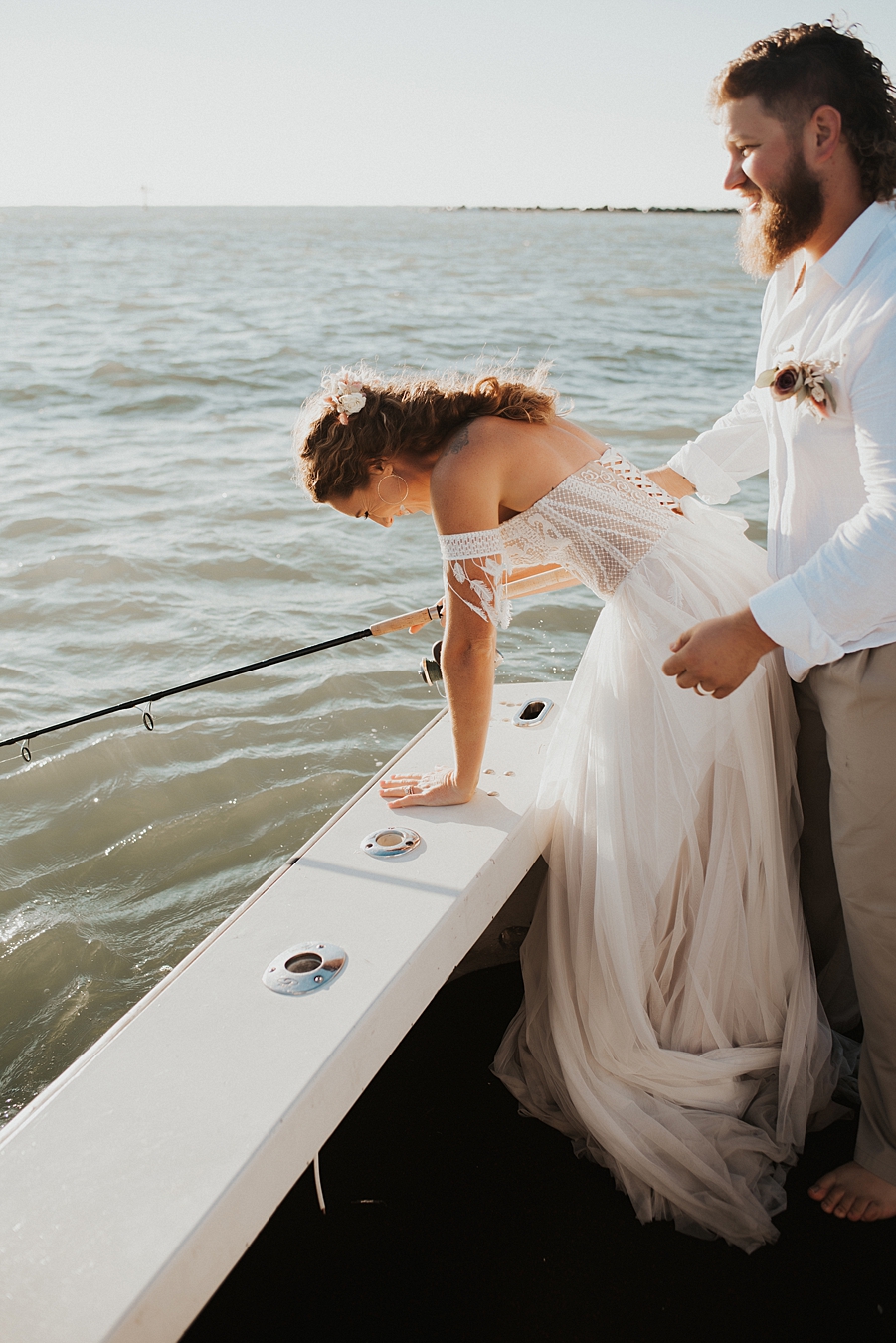 Bride and groom fishing on back of boat