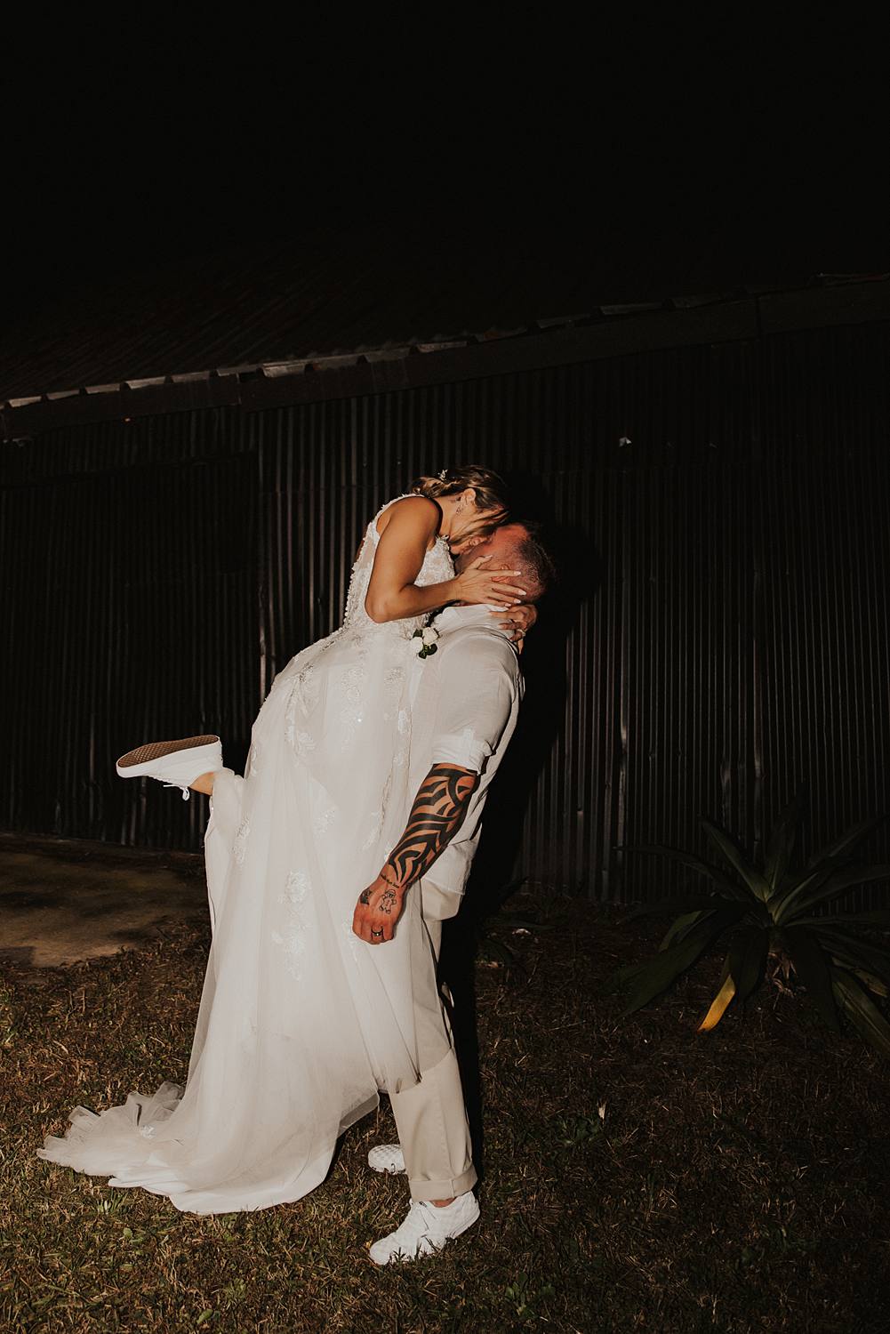 Groom picking up bride and kissing her