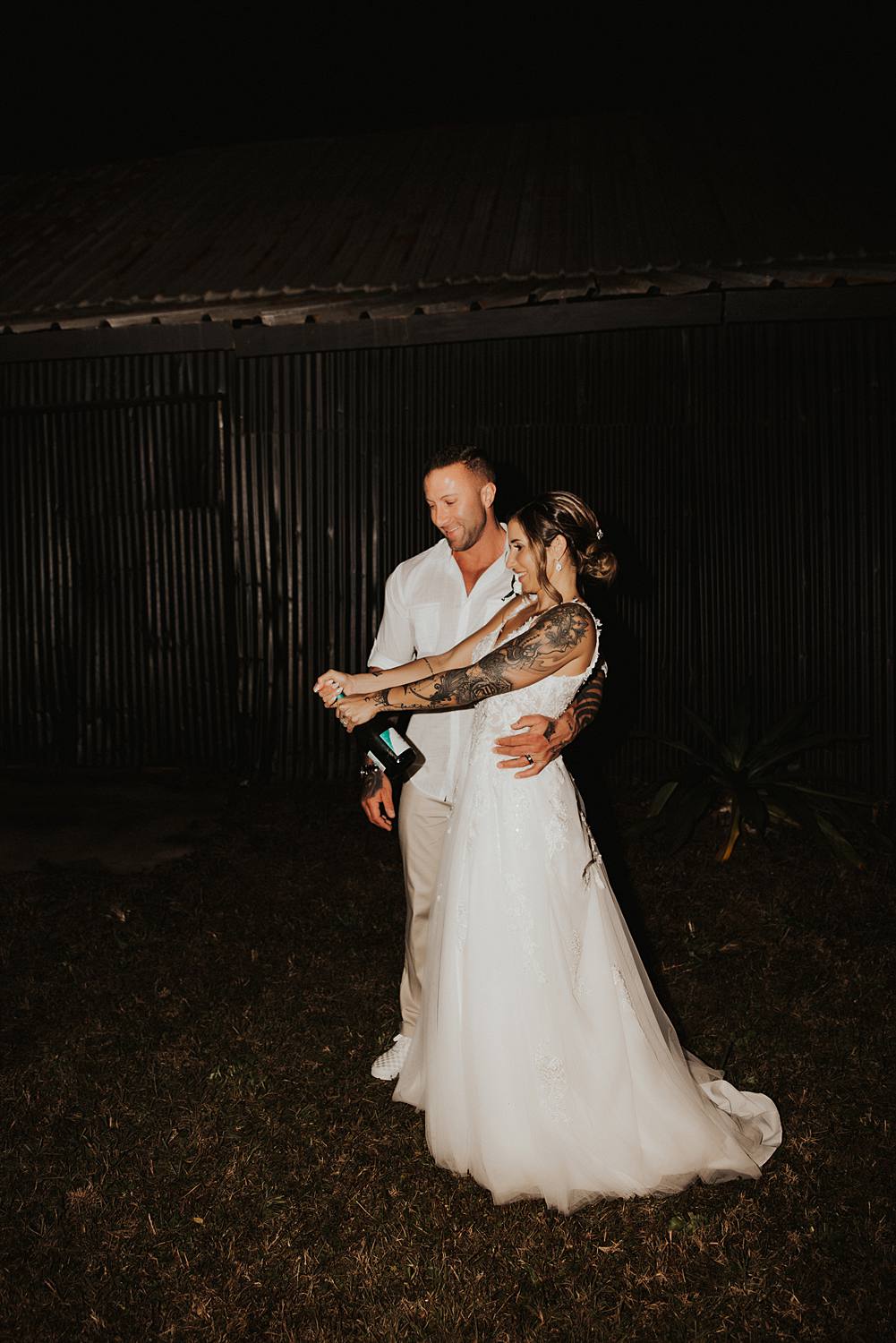 Bride and groom popping champagne at night