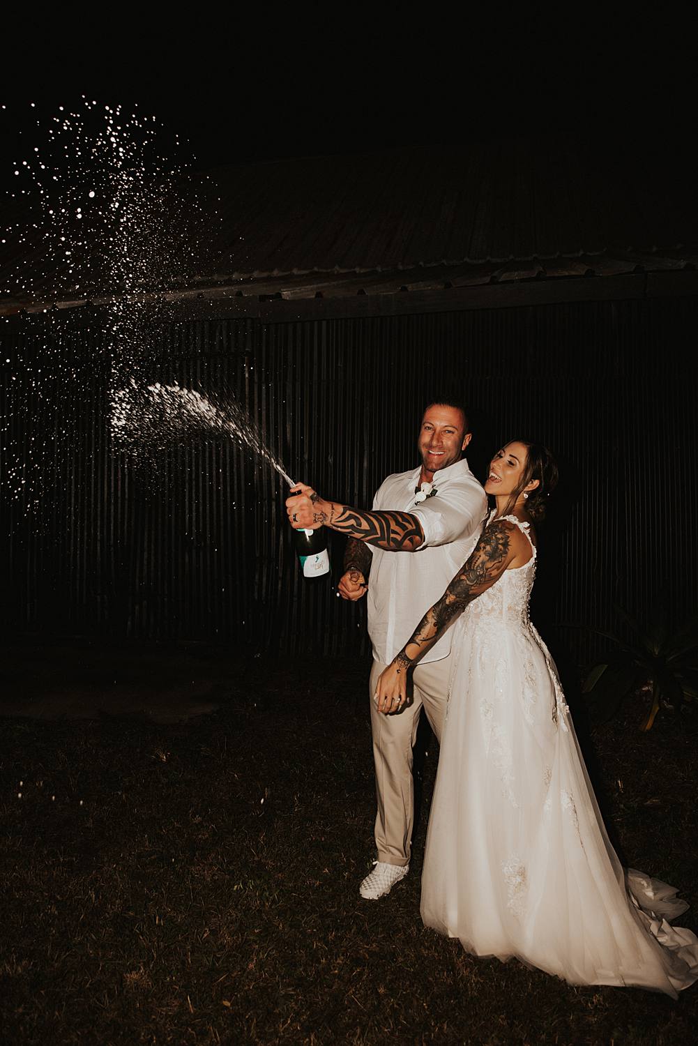 Bride and groom popping champagne at night