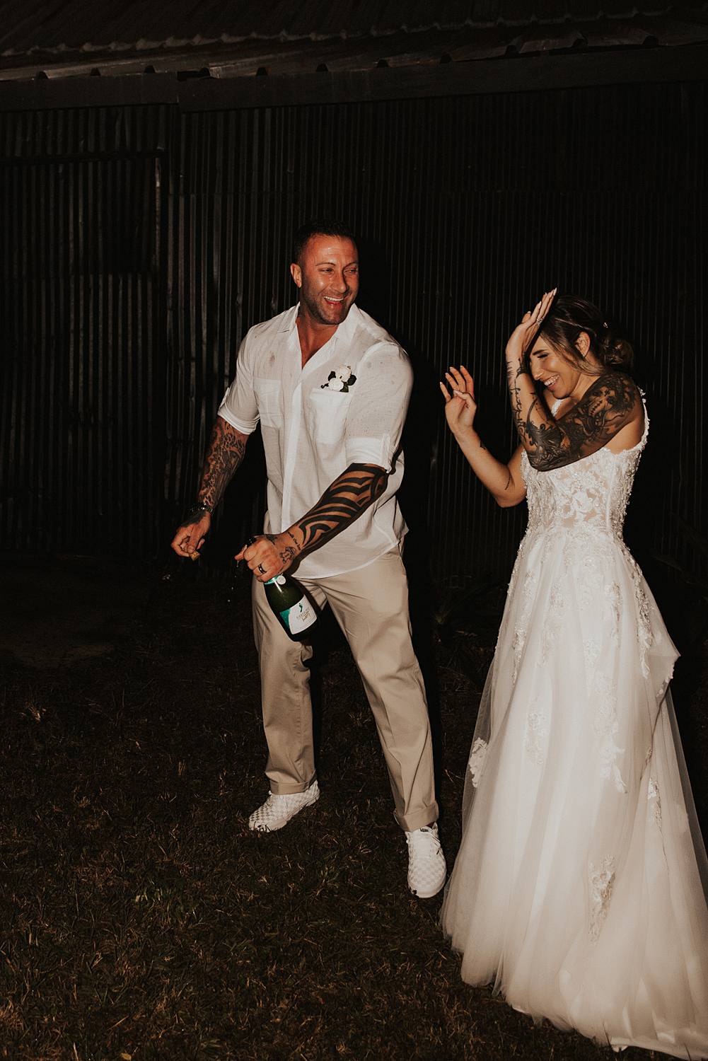 Bride and groom popping champagne at night