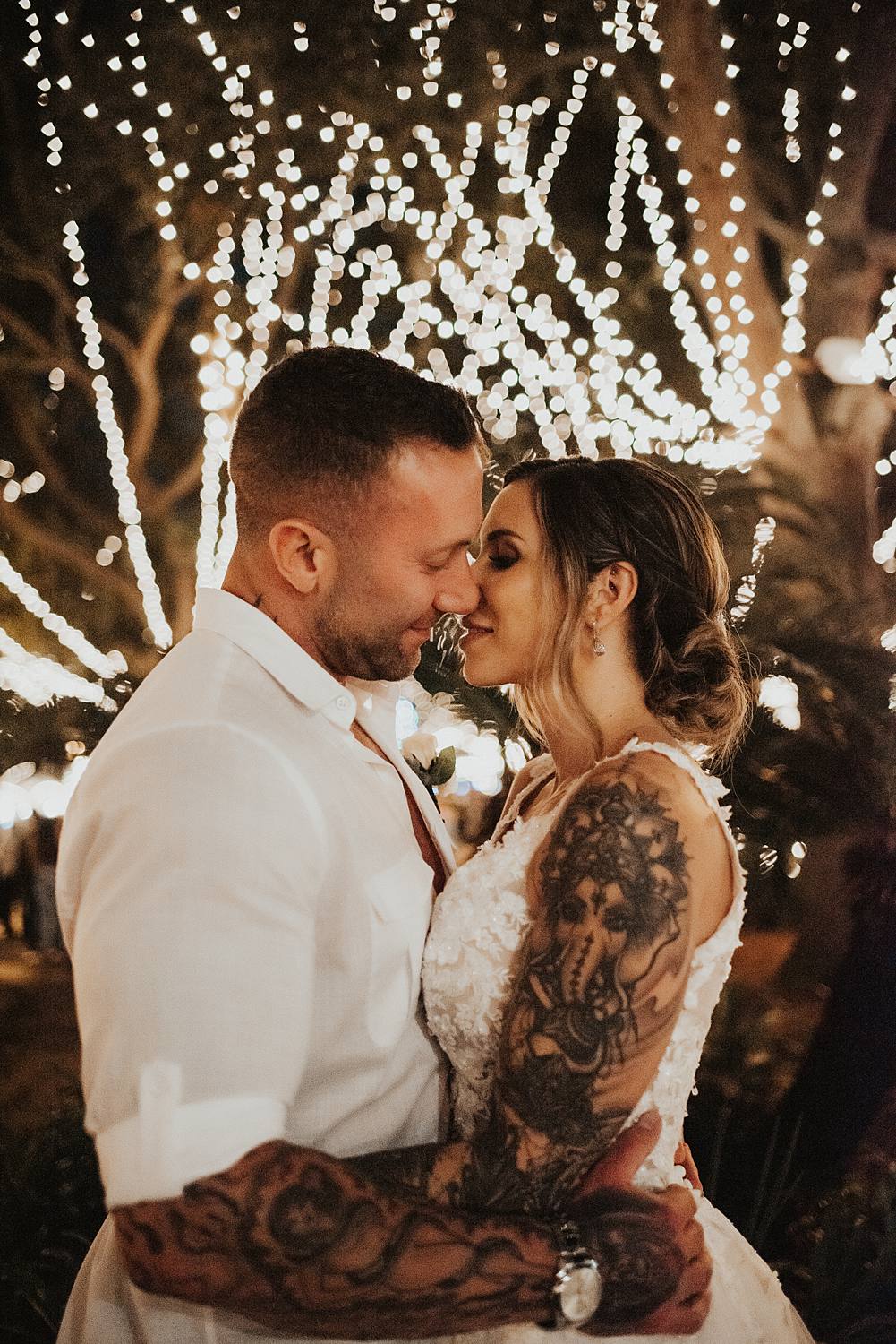 Bride and groom kissing at night of lights