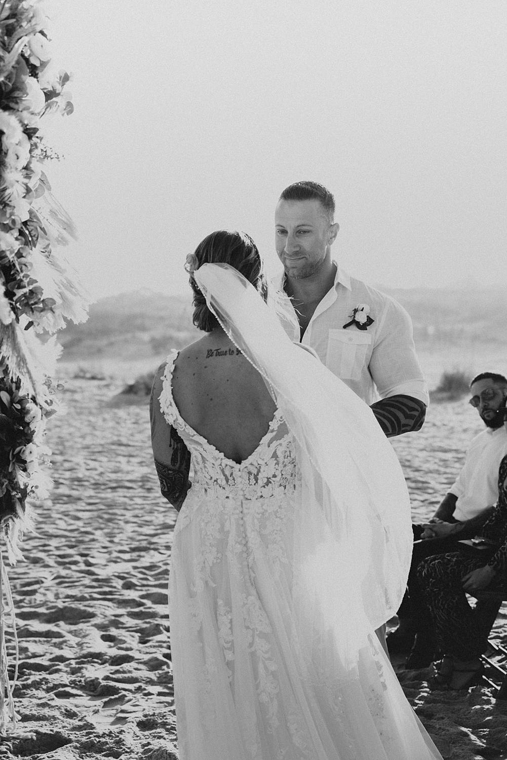 Groom reading vows to bride at beach wedding