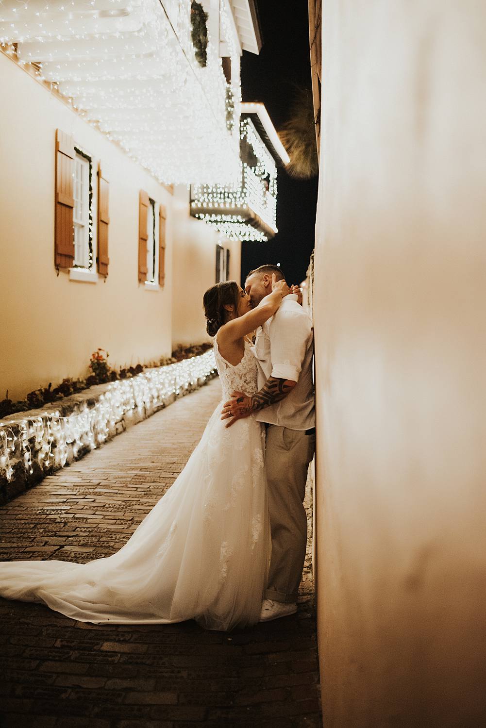 Bride kissing groom against a wall