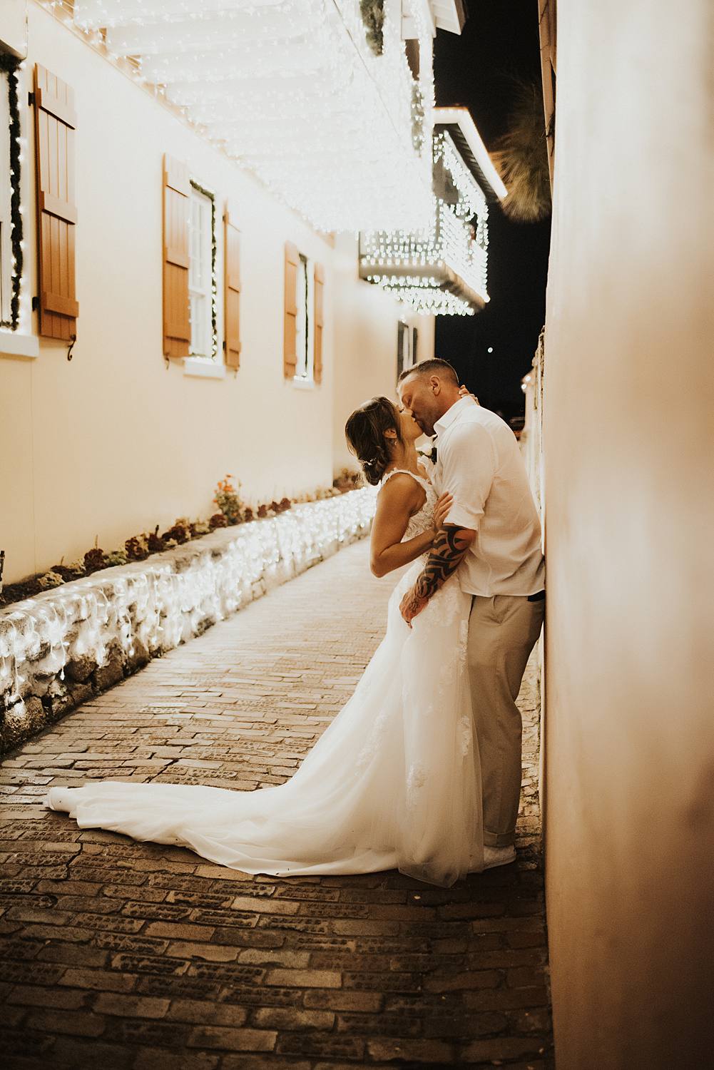 Bride kissing groom against a wall