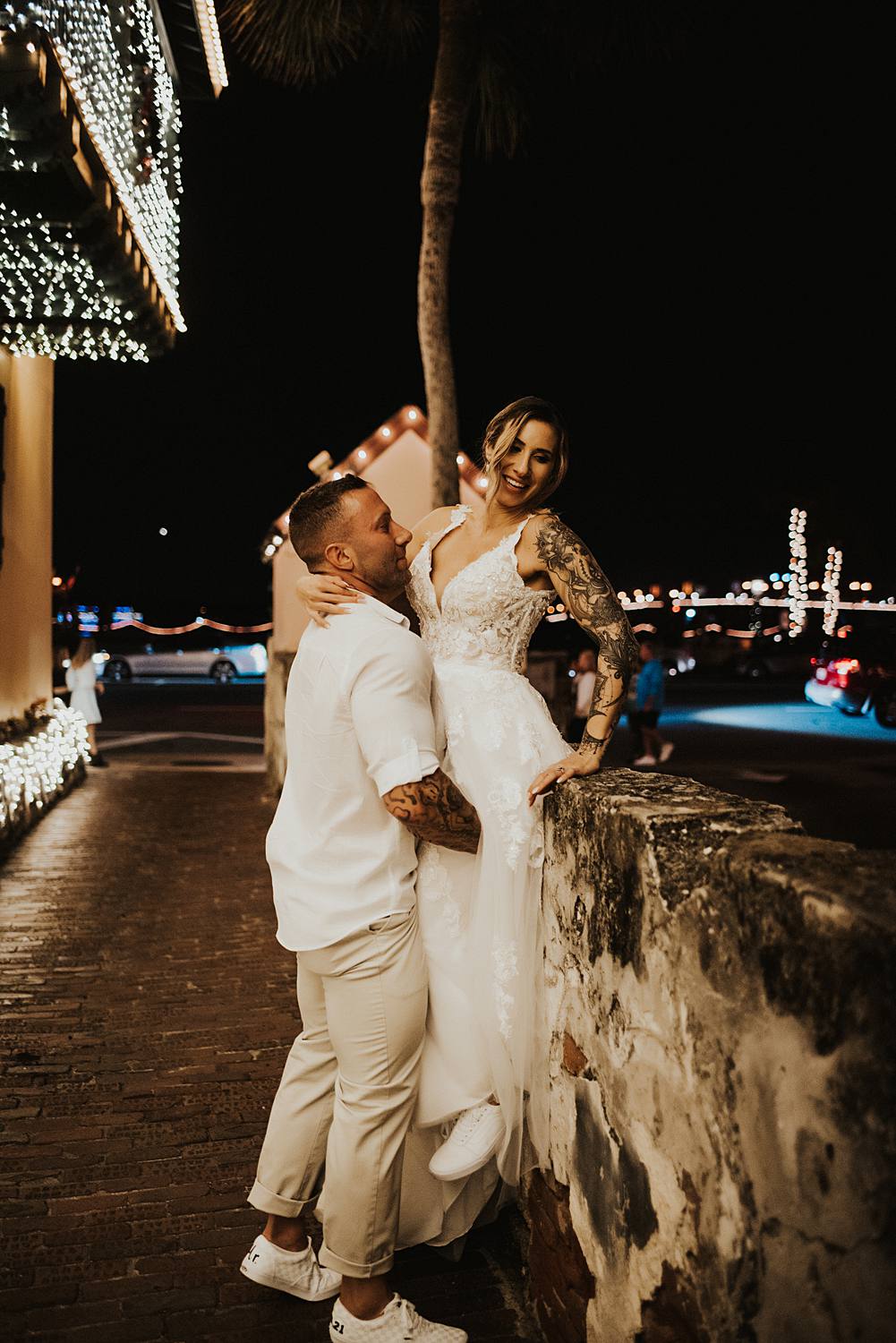 Groom picking up bride onto a wall