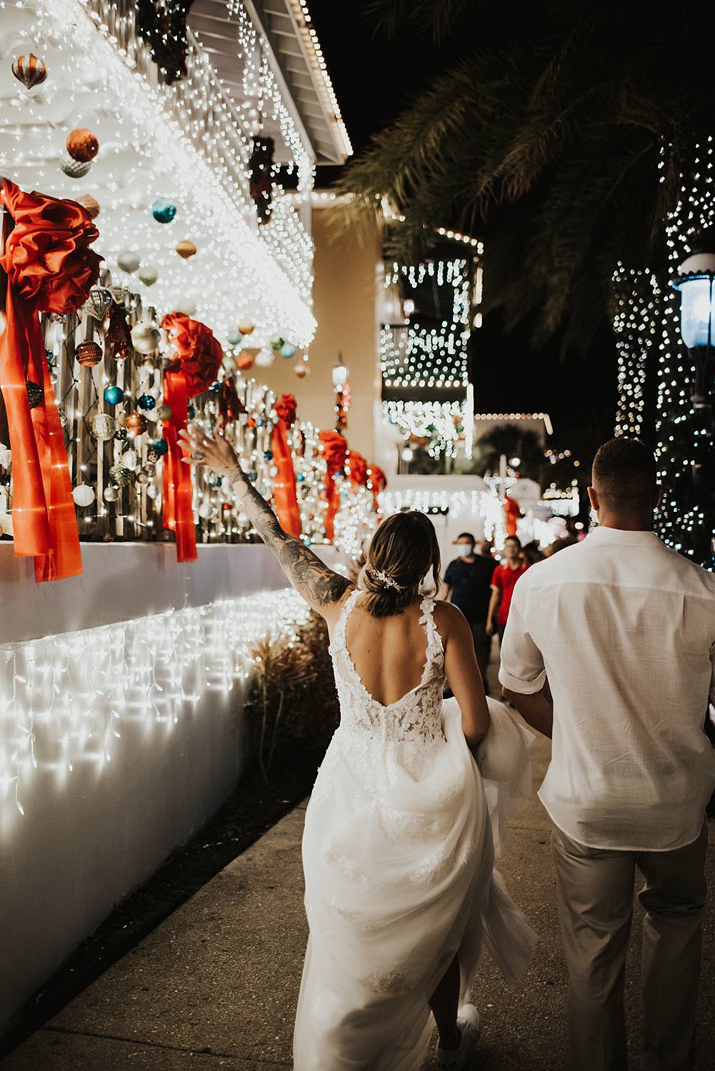 Bride walking down sidewalk during night of lights