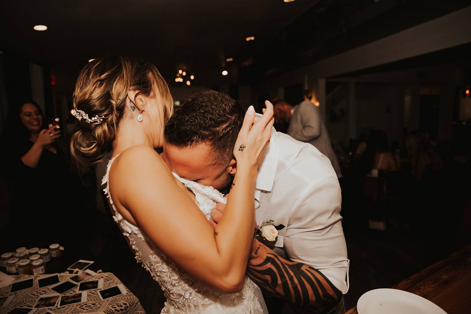 Groom eating cake off bride