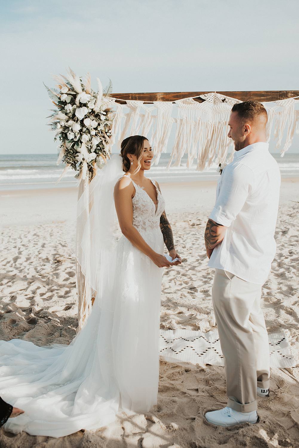 Bride reading vows to groom at beach wedding