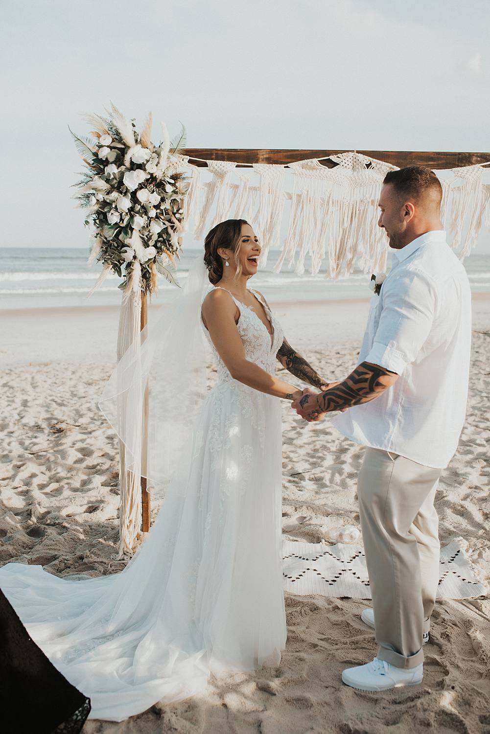 Groom placing ring on brides finger at beach wedding