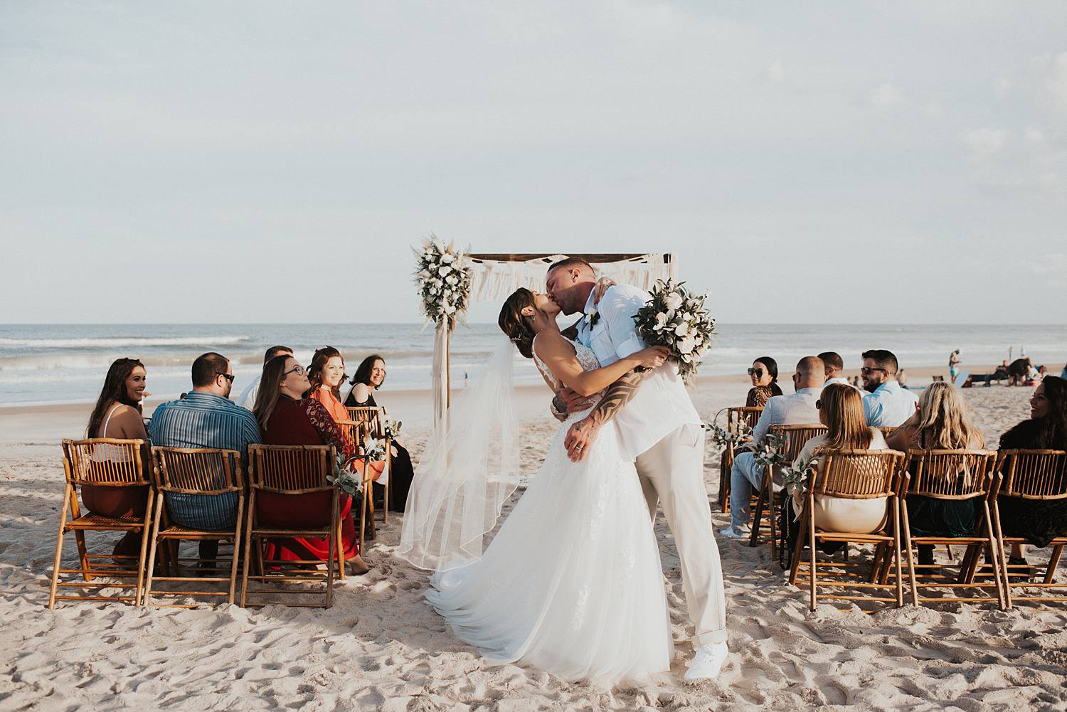 Bride and groom's first kiss at beach wedding