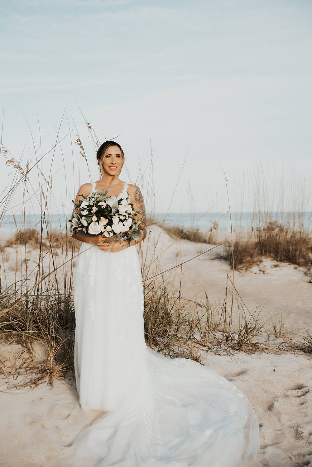 Bride holding bouquet on beach for bridal portraits