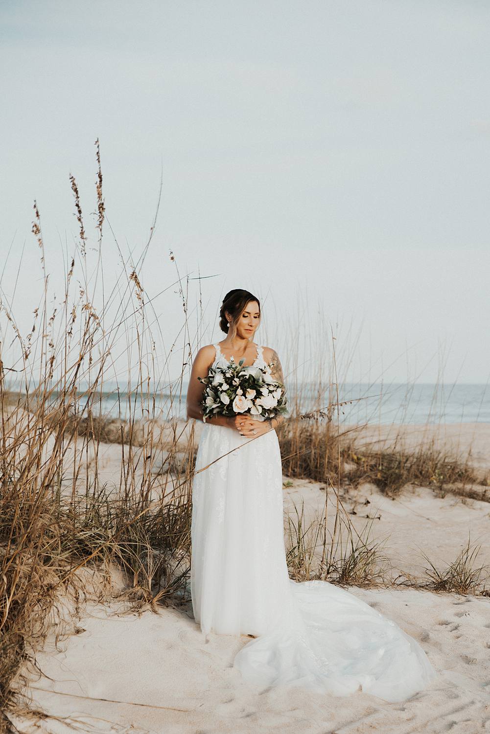Bride holding bouquet on beach for bridal portraits