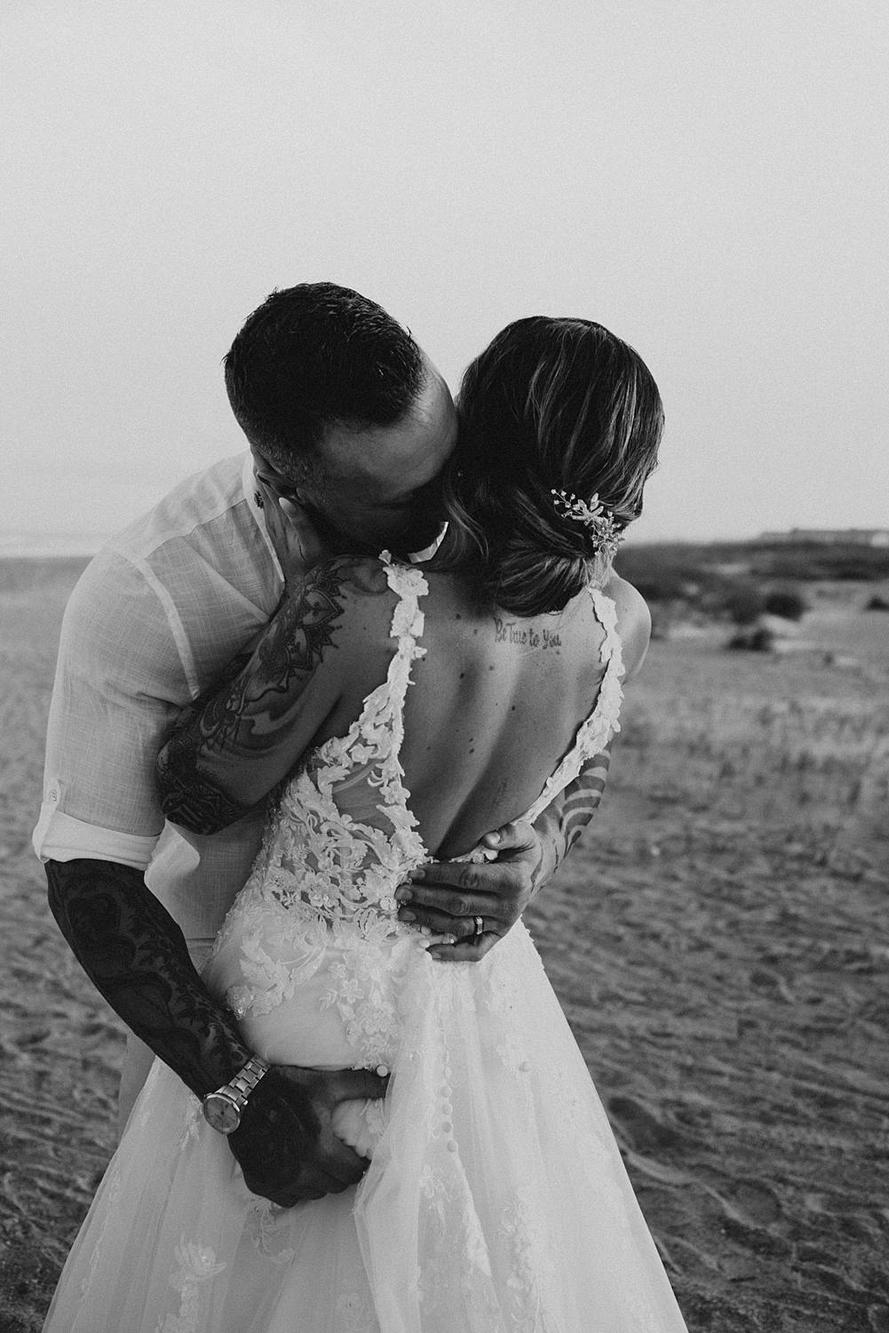 Groom grabbing bride's butt on beach