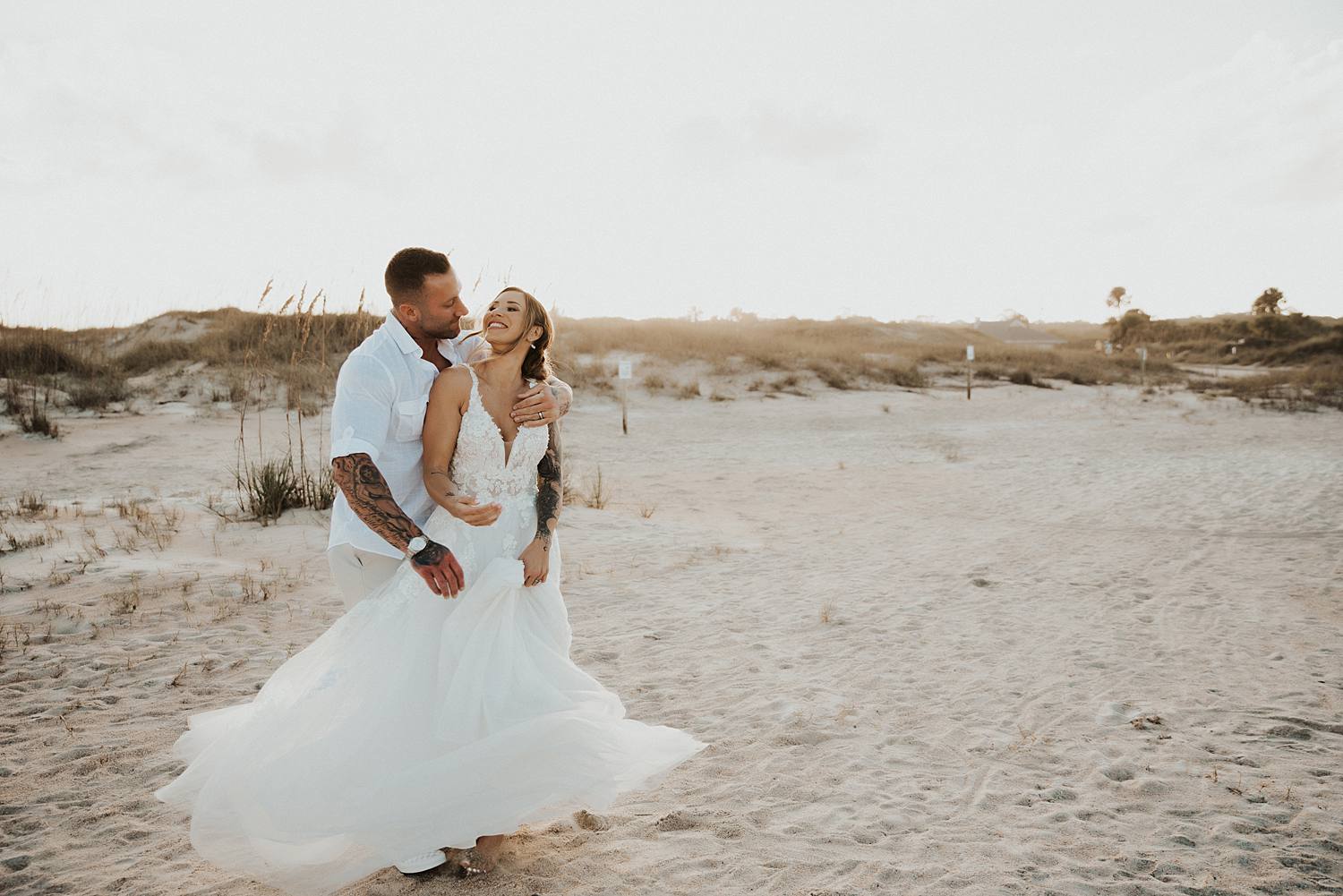 Bride and groom swinging on the beach