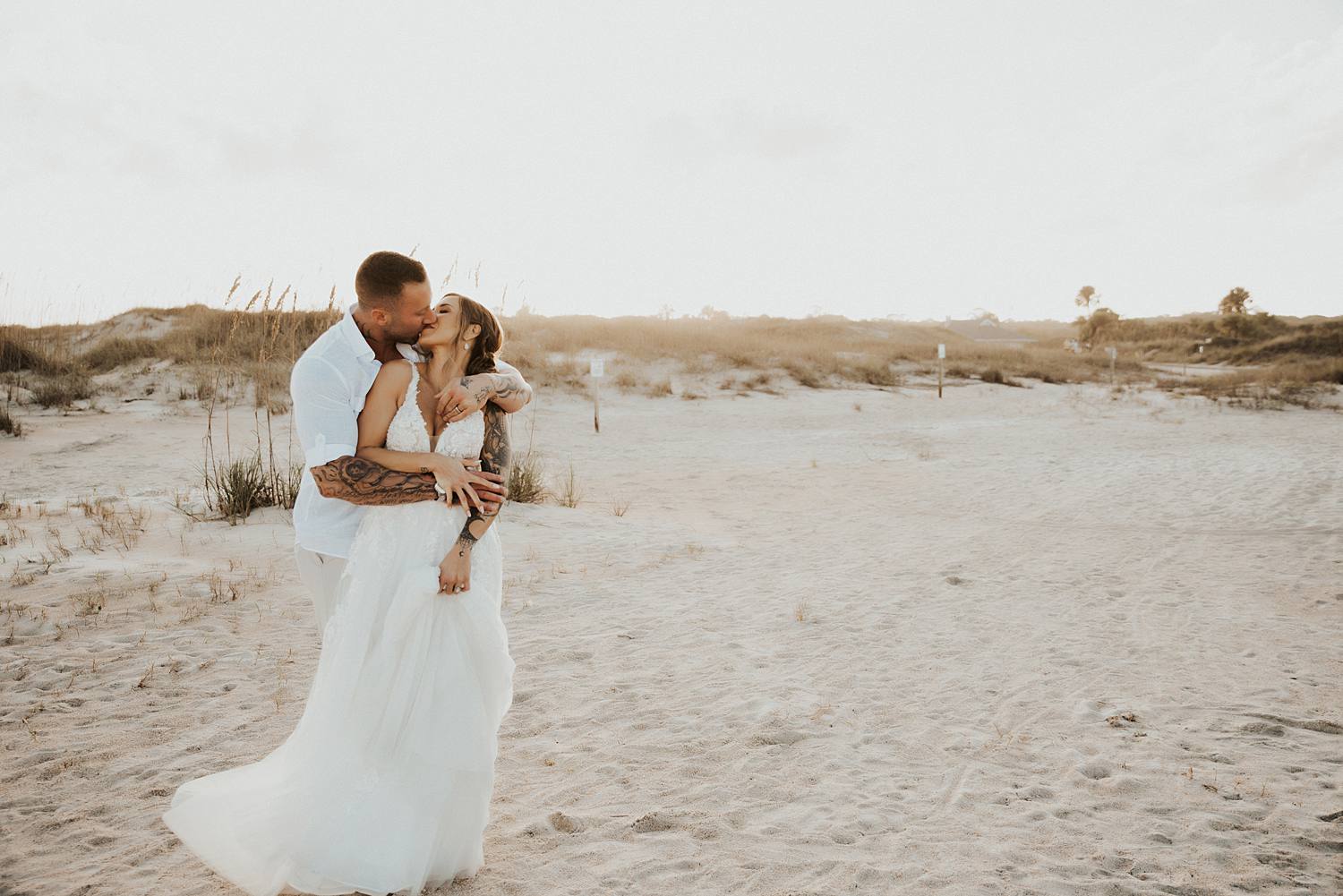 Bride and groom kissing on beach