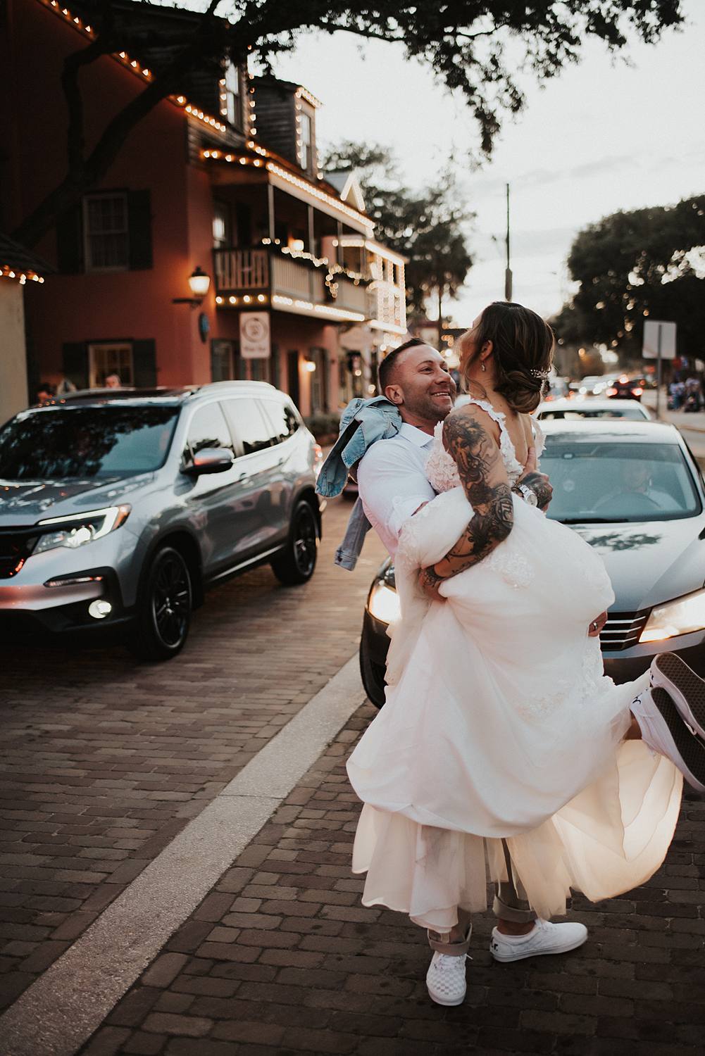 Groom picking up bride Bride and groom kissing Bride and groom joking around on Saint George street