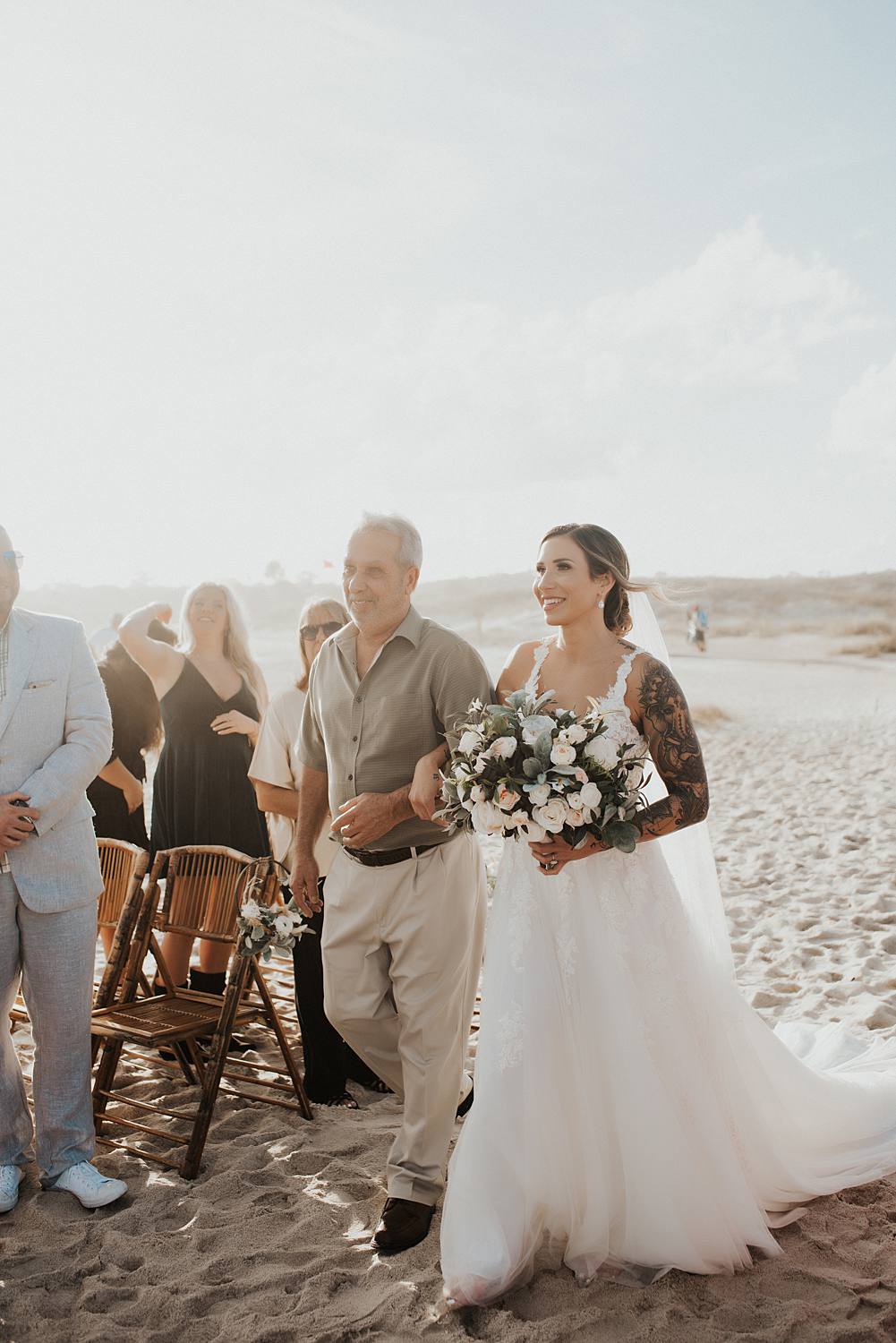 Father walking bride down the aisle at beach wedding
