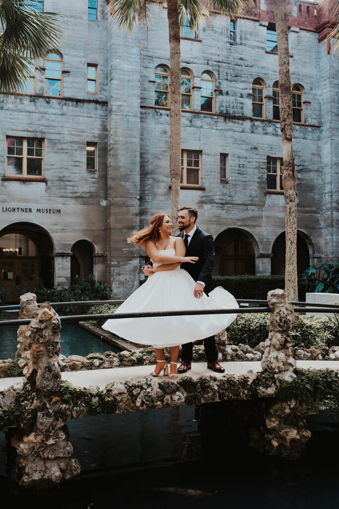 Groom spinning bride on the stone bridge at the Lightner Museum courtyard