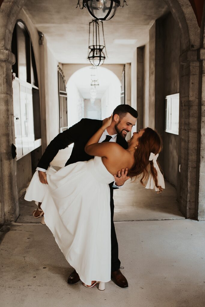 Groom dipping bride at the Lightner Museum after their Lightner Museum courtyard elopement