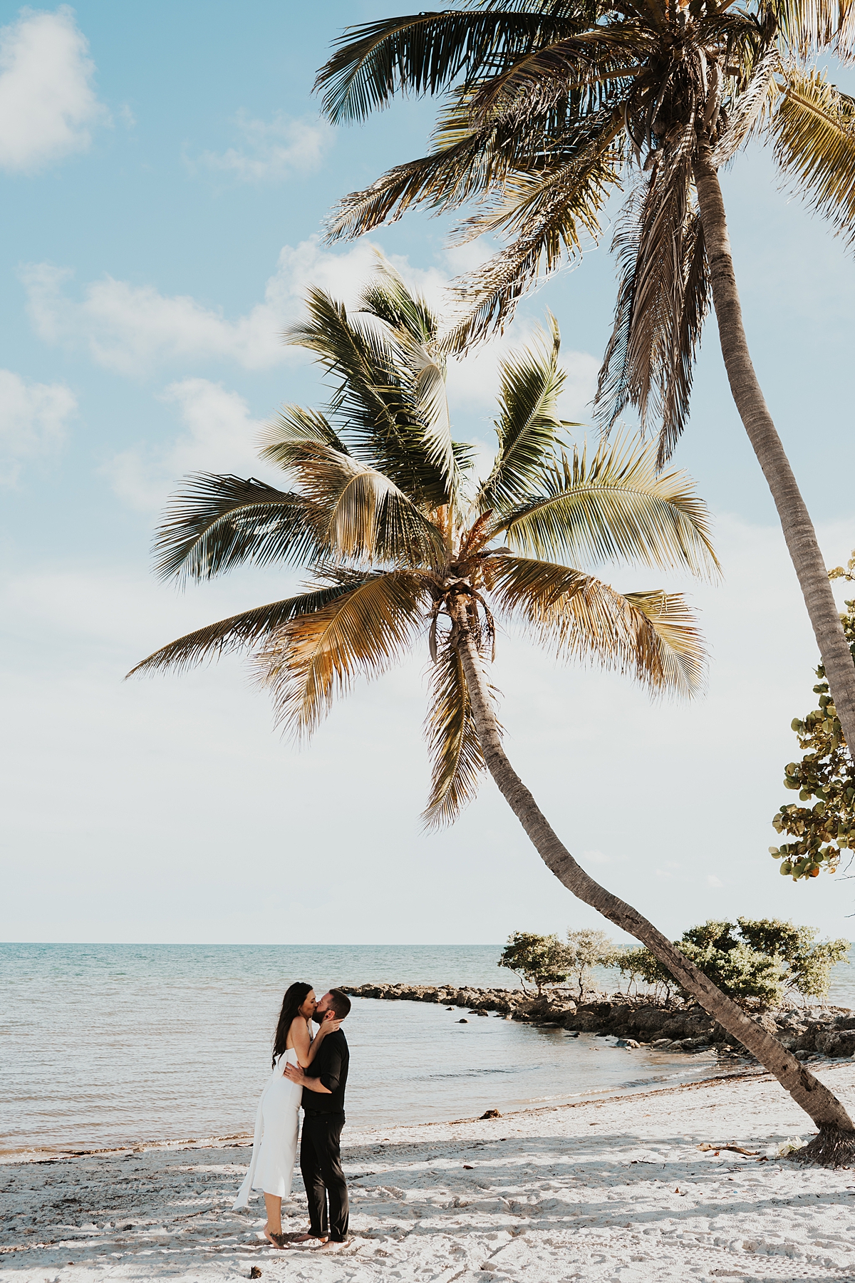 Bride and groom having their first kiss during their Key West elopement on Smathers Beach in September