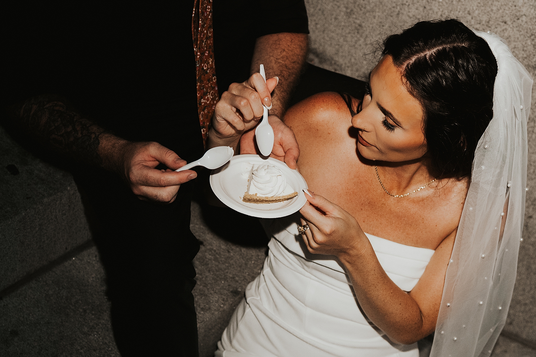 Bride and groom eating key lime pie on steps in Key West after their elopement with flash photography
