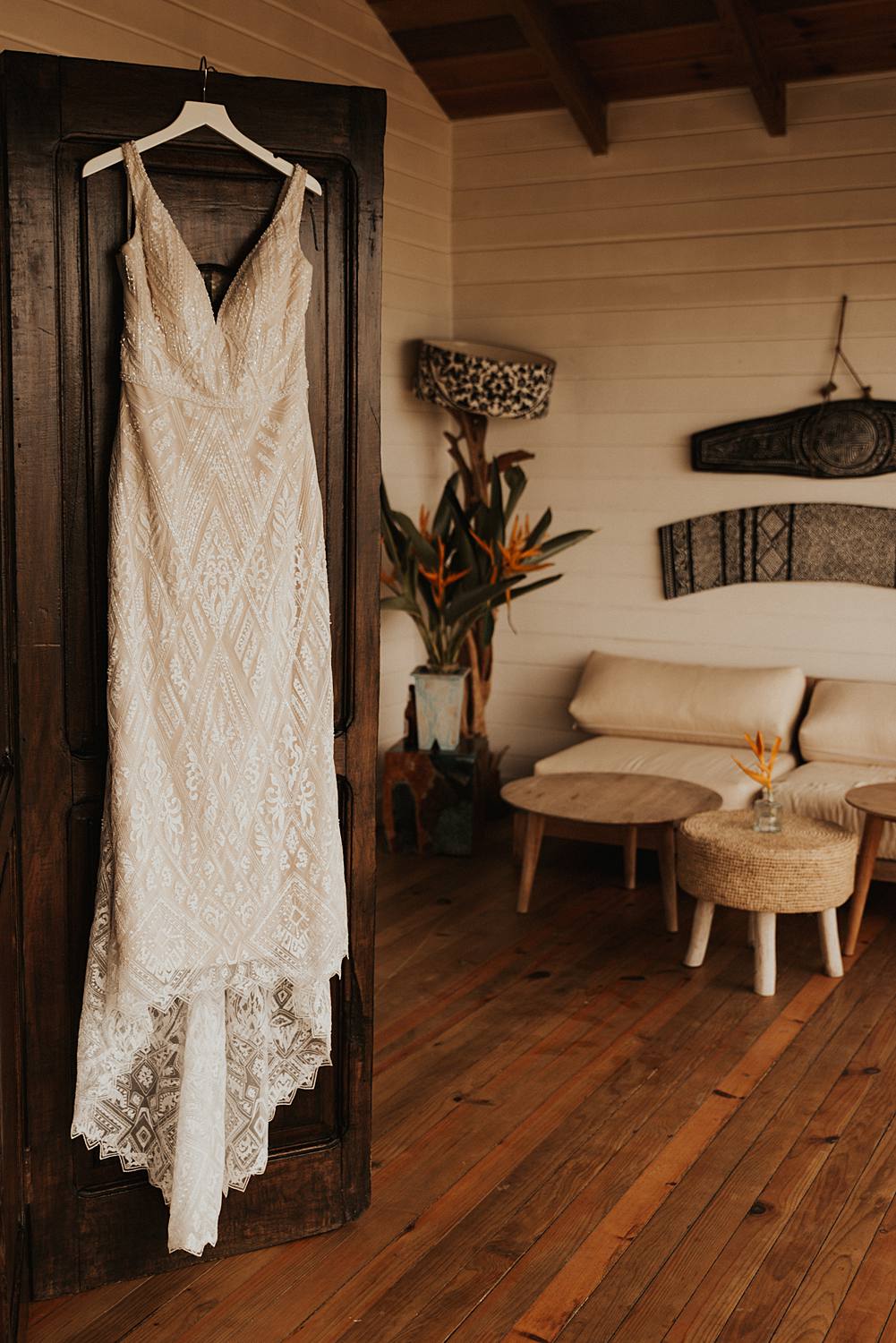 Lace wedding dress hanging in tropical boutique hotel