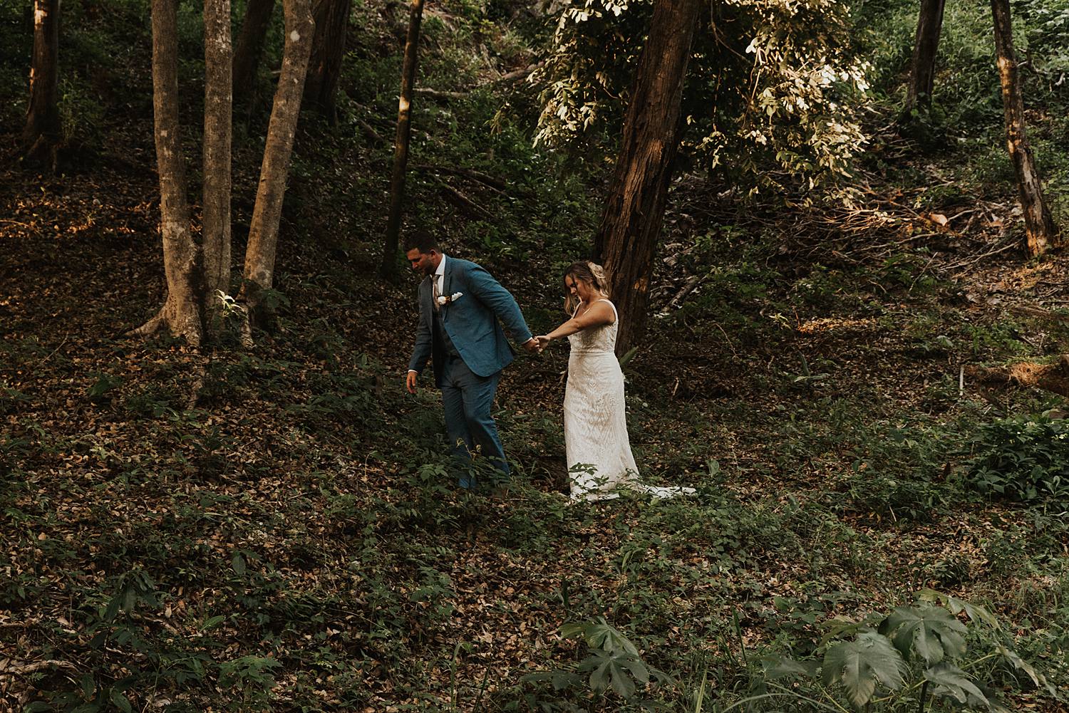 Bride and groom hiking in tropical rain forest in Roatan, Honduras