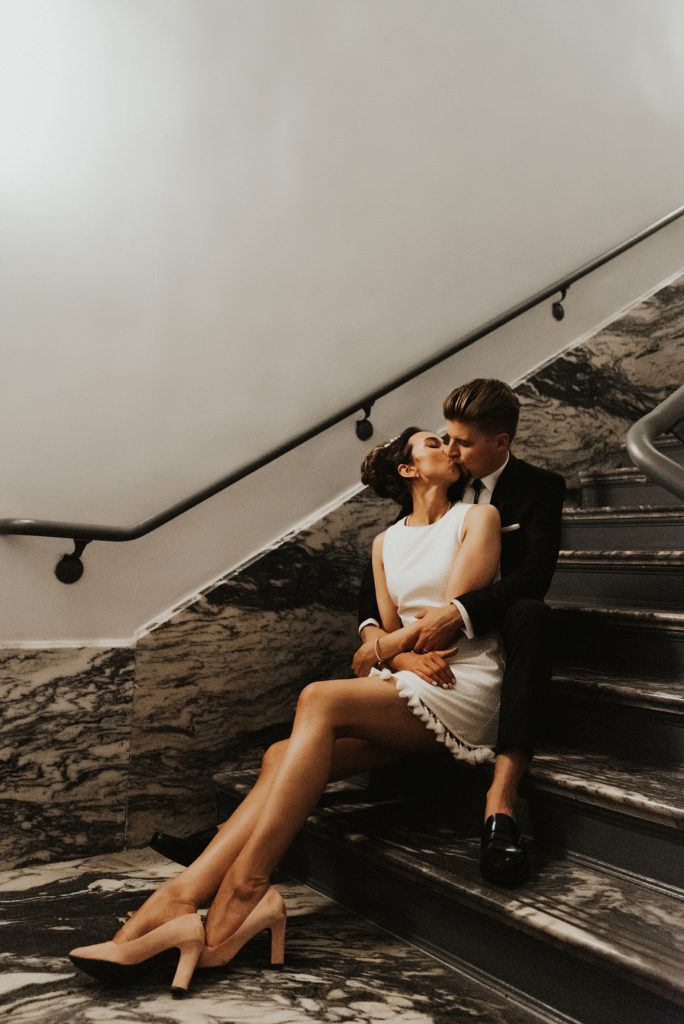 Bride and groom sitting on Le Meridien Tampa marble steps