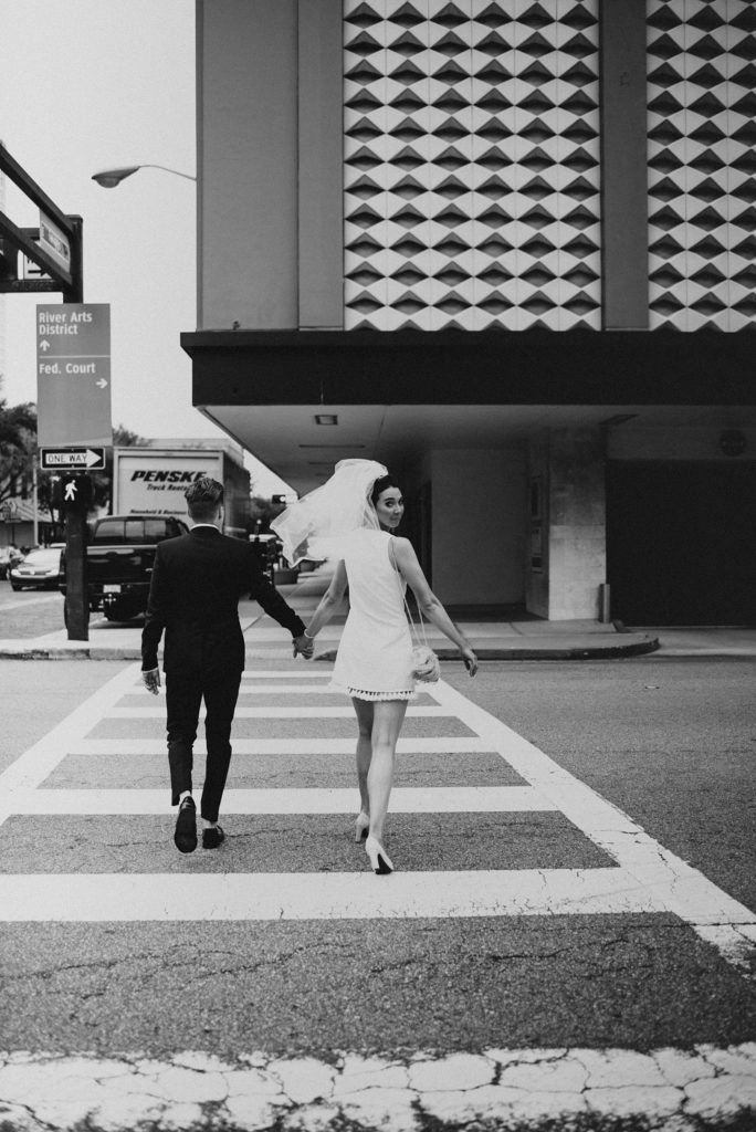Bride and groom crossing downtown tampa street