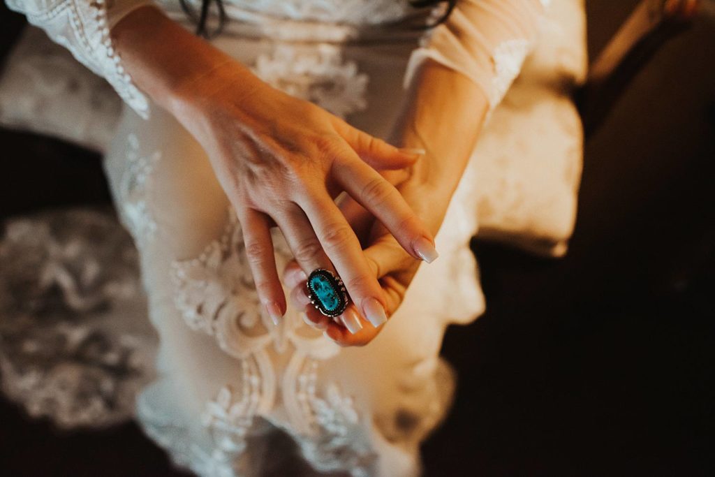 Bride putting on turquoise and silver ring prior to wedding ceremony