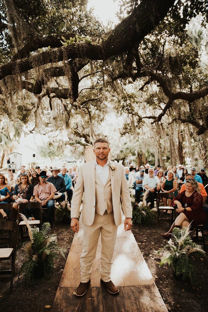 Groom walking down the aisle during oak trees for okeechobee florida wedding ceremony