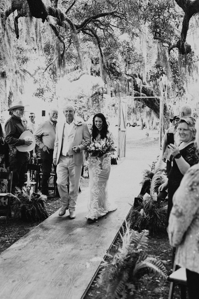 Bride walking down the aisle in an outdoor ceremony in okeechobee florida