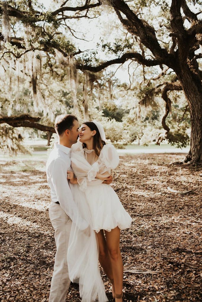 Bride and groom under oak trees