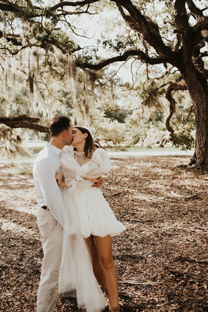 Bride and groom under oak trees