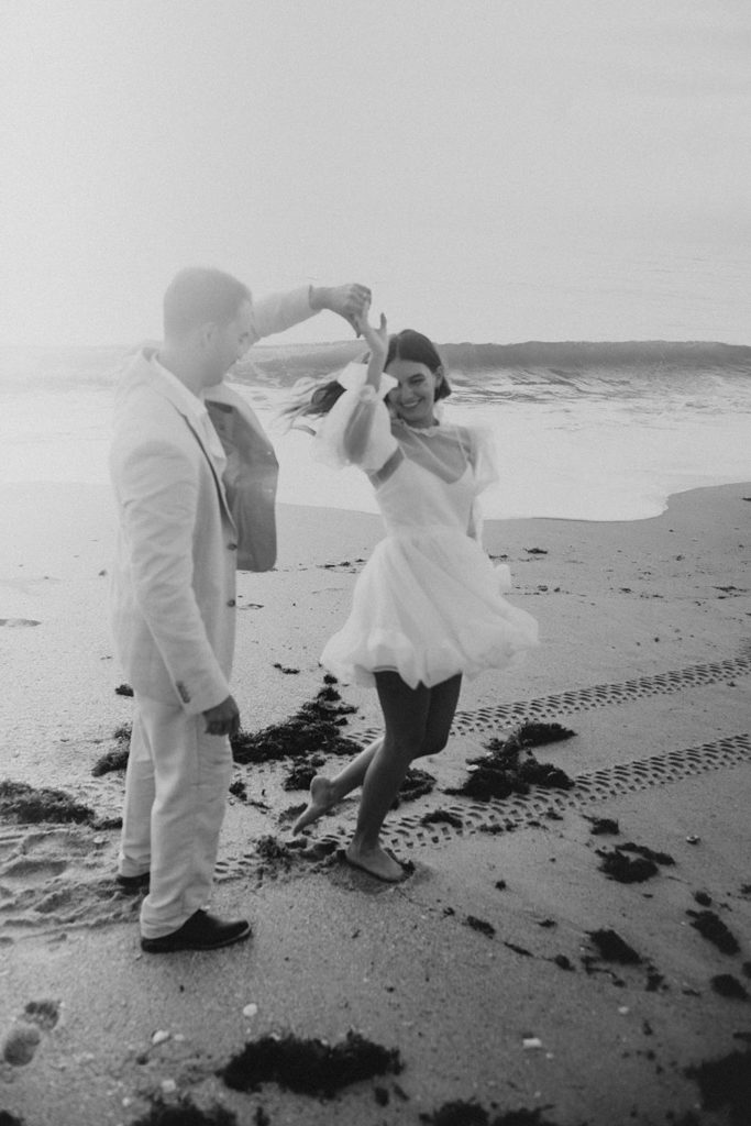 Bride and groom dancing on beach