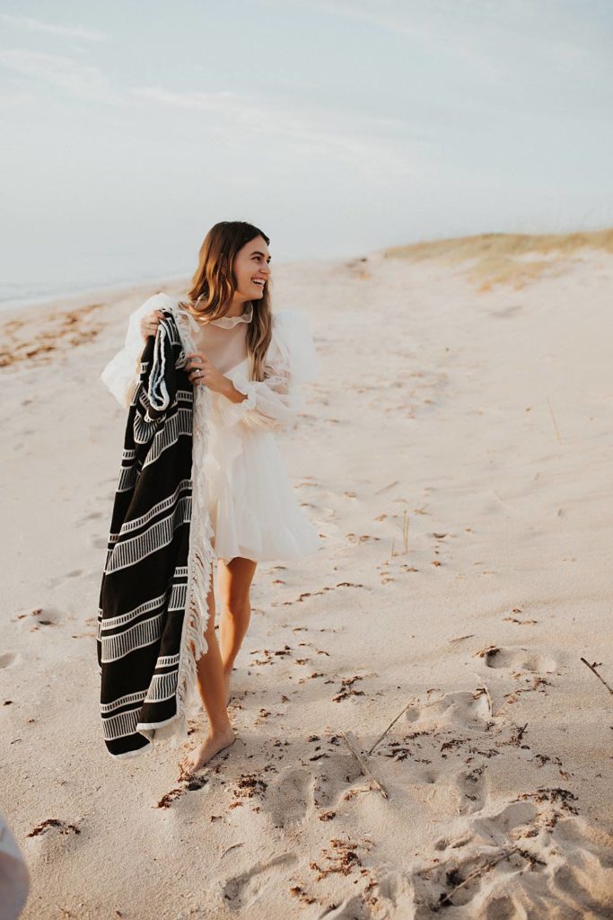 Bride with black and white blanket on beach