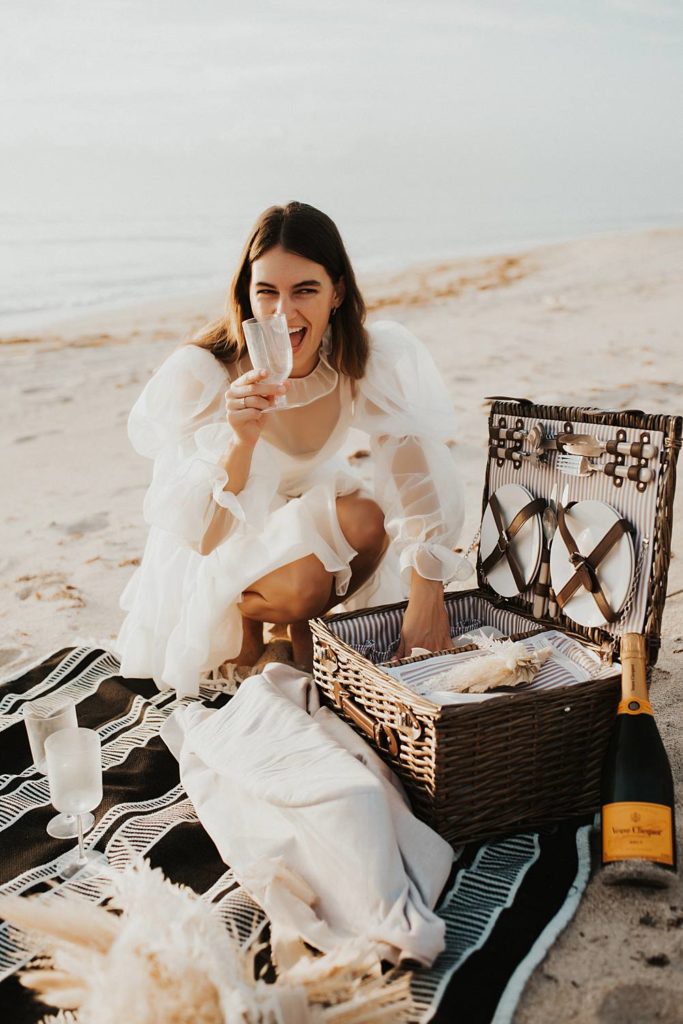 Bride setting up an elopement picnic on beach