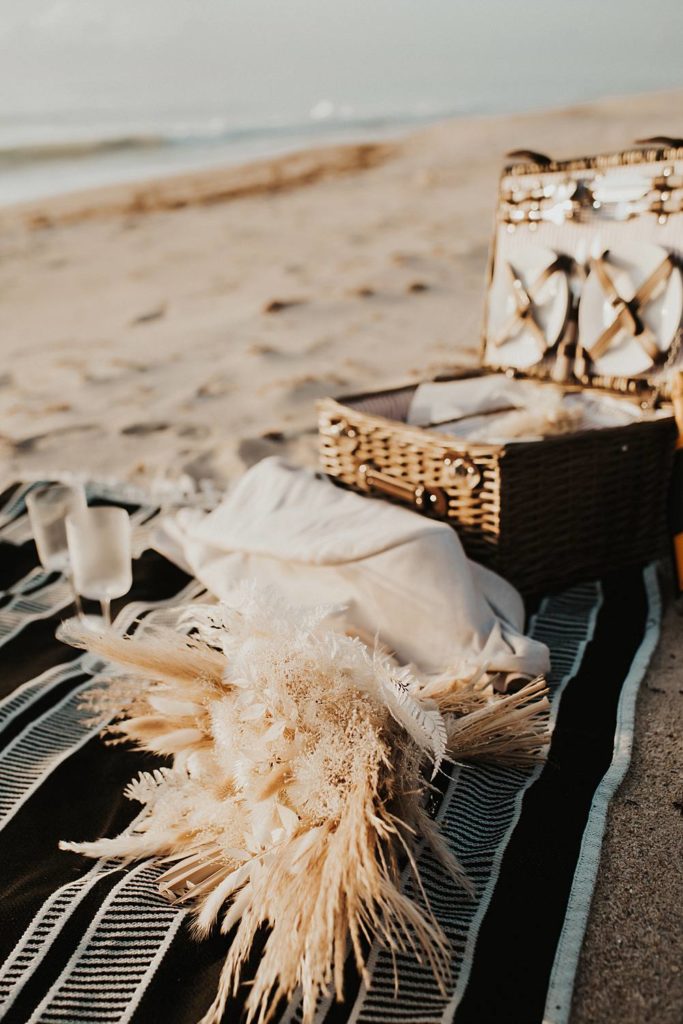 Elopement picnic details on beach with black and white blanket