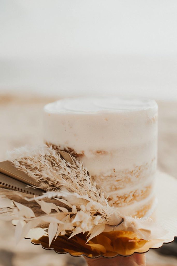 Mini rustic layered cake with dried flowers on the beach