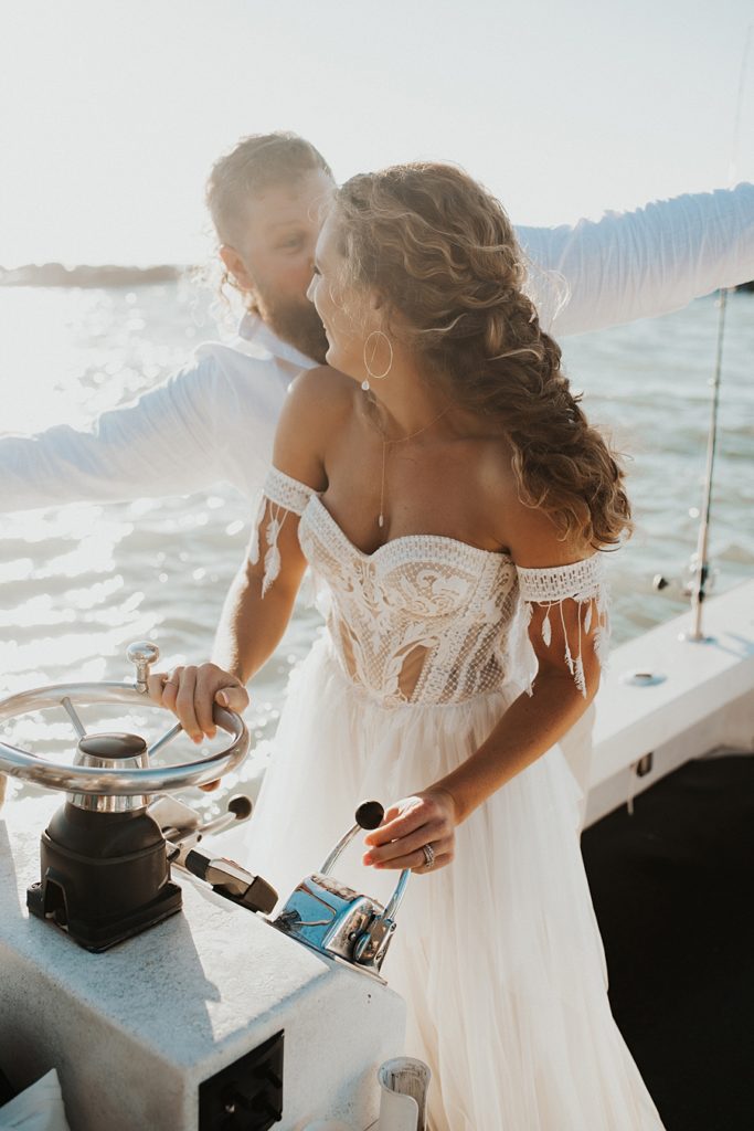 Bride driving boat during elopement
