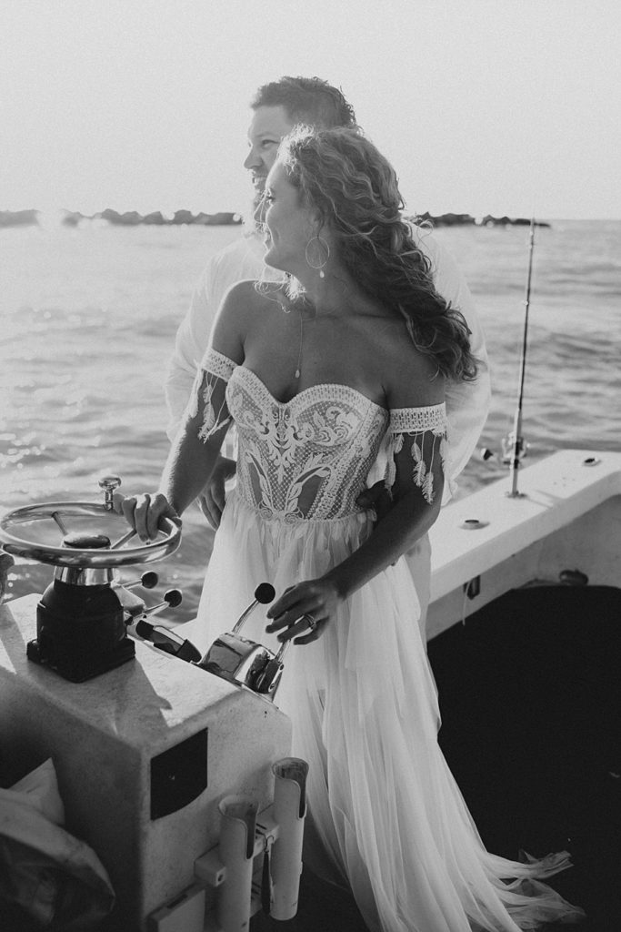 Bride driving boat during elopement