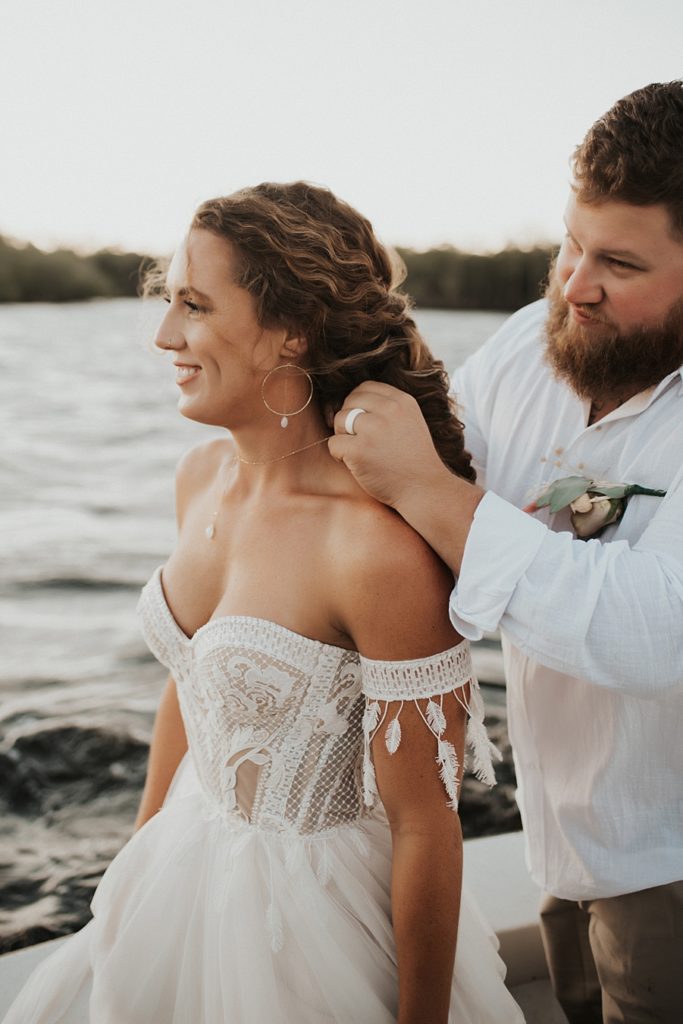 Groom putting on brides necklace during elopement