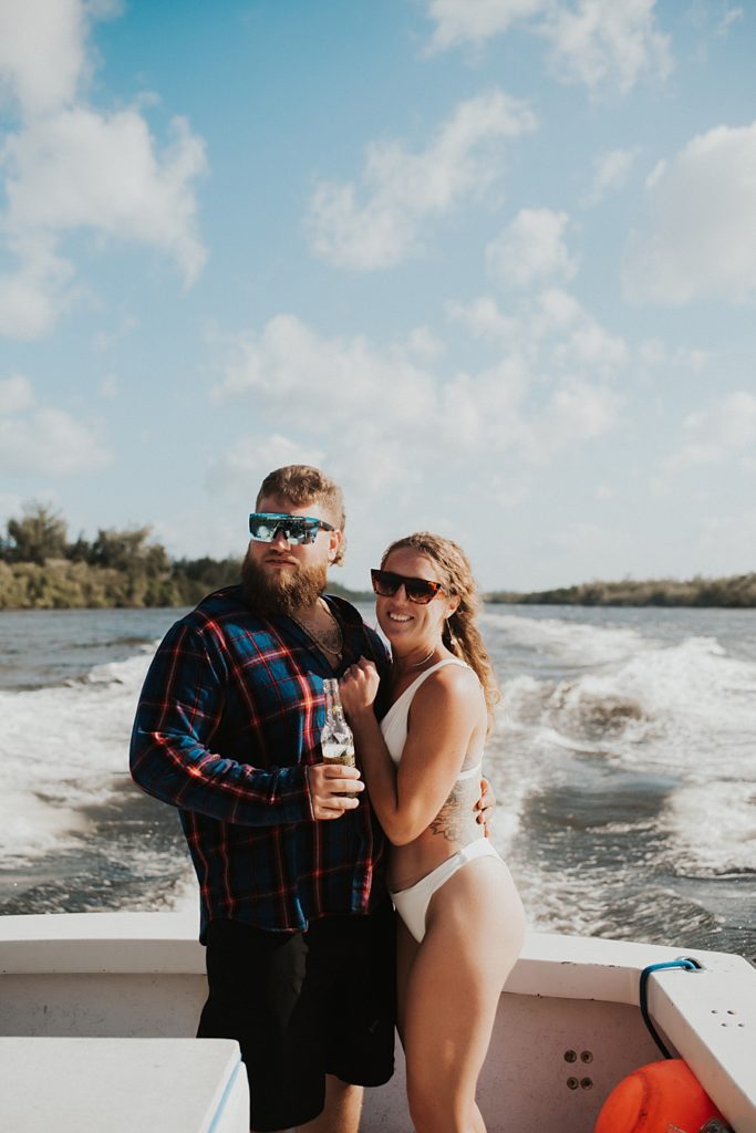 Bride and groom in flannel cuddling on boat