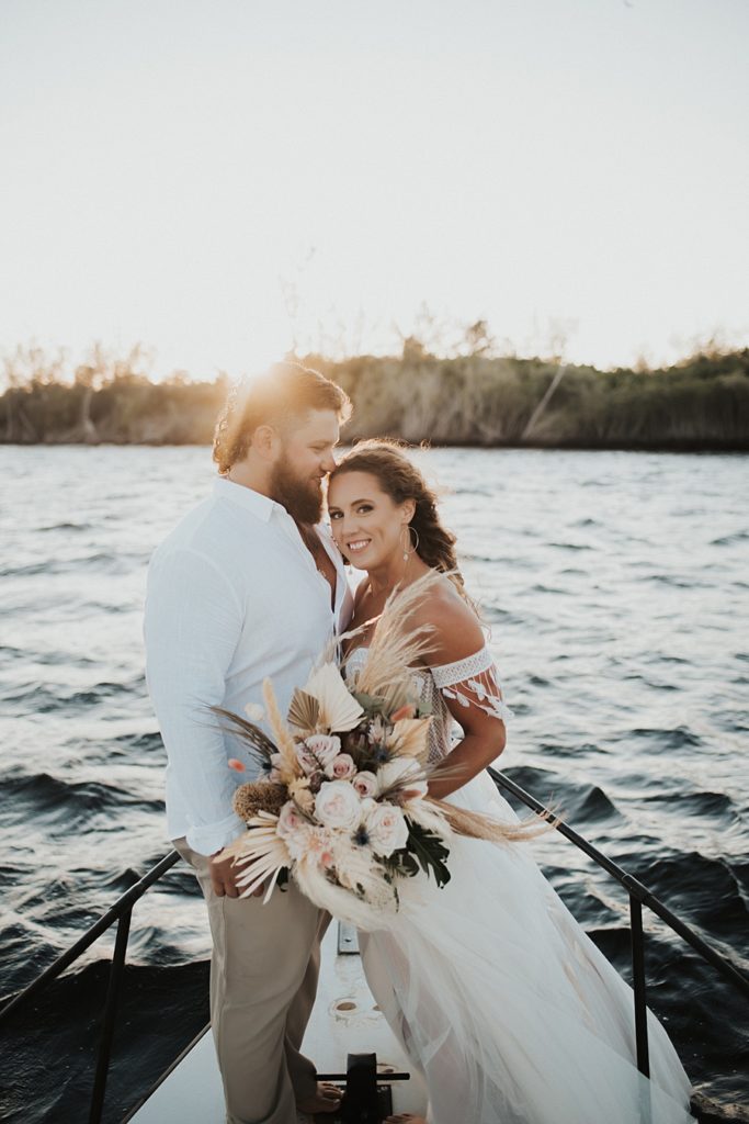 Bride holding bouquet on front of boat